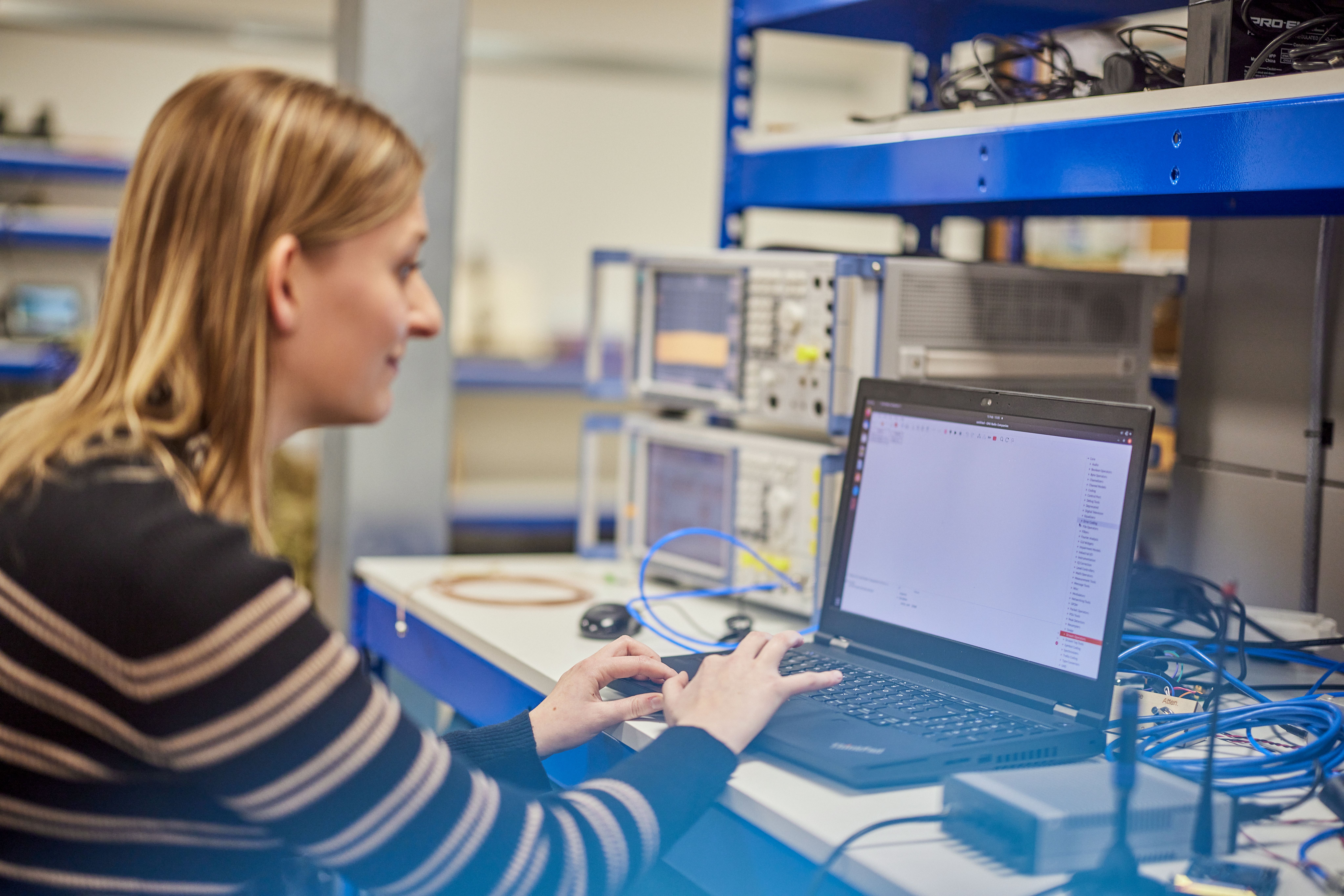 A person working at a laptop in a lab.